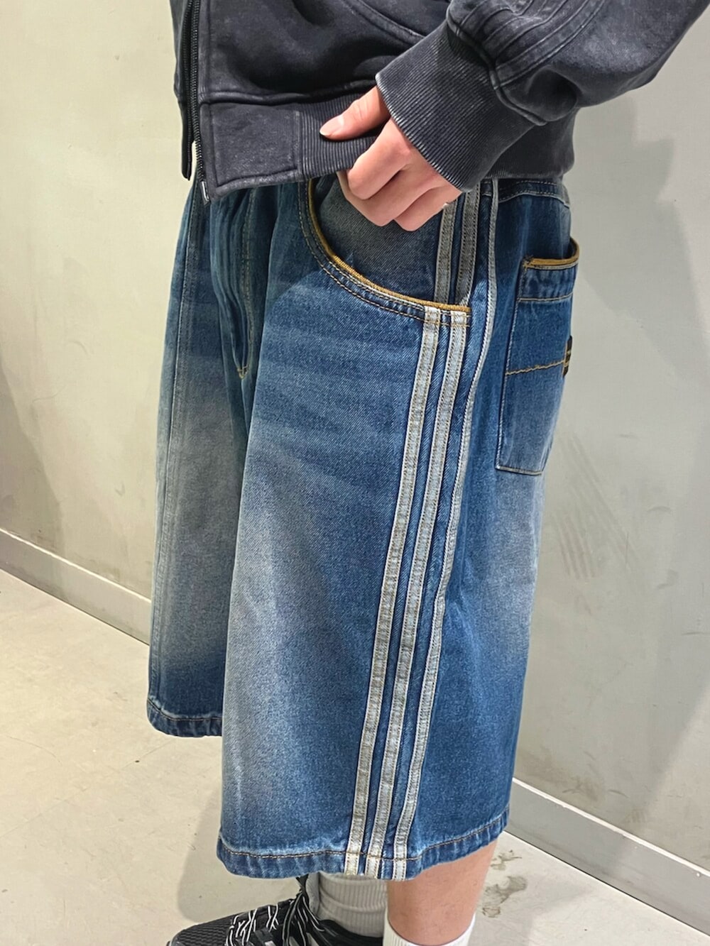 ブラック系のパーカー、ブラック系のショルダーバッグ、ブラック系のスニーカーを着用したメンズの冬コーディネートの4枚目の写真