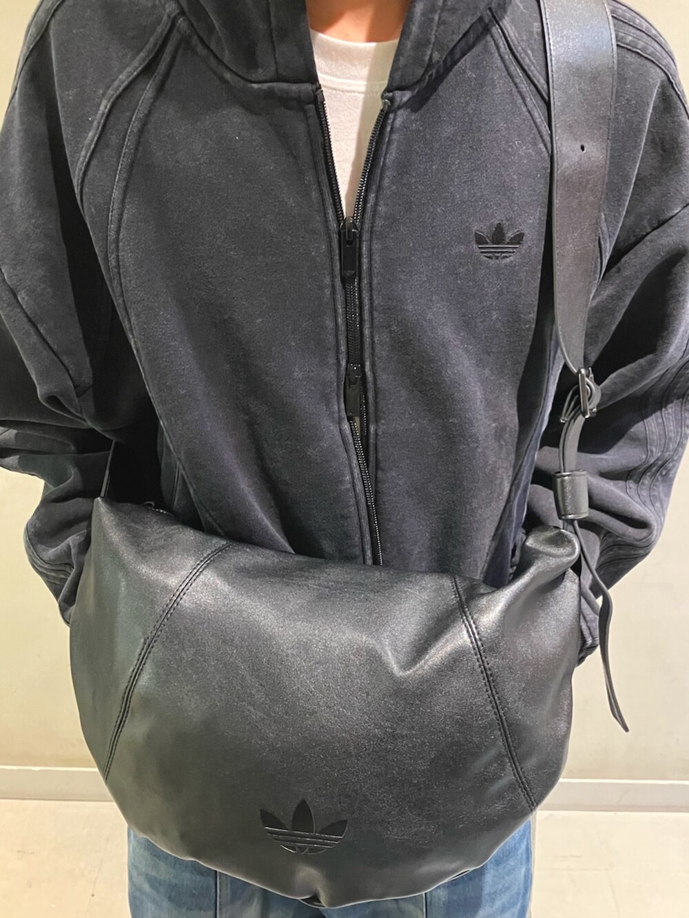 ブラック系のパーカー、ブラック系のショルダーバッグ、ブラック系のスニーカーを着用したメンズの冬コーディネートの5枚目の写真