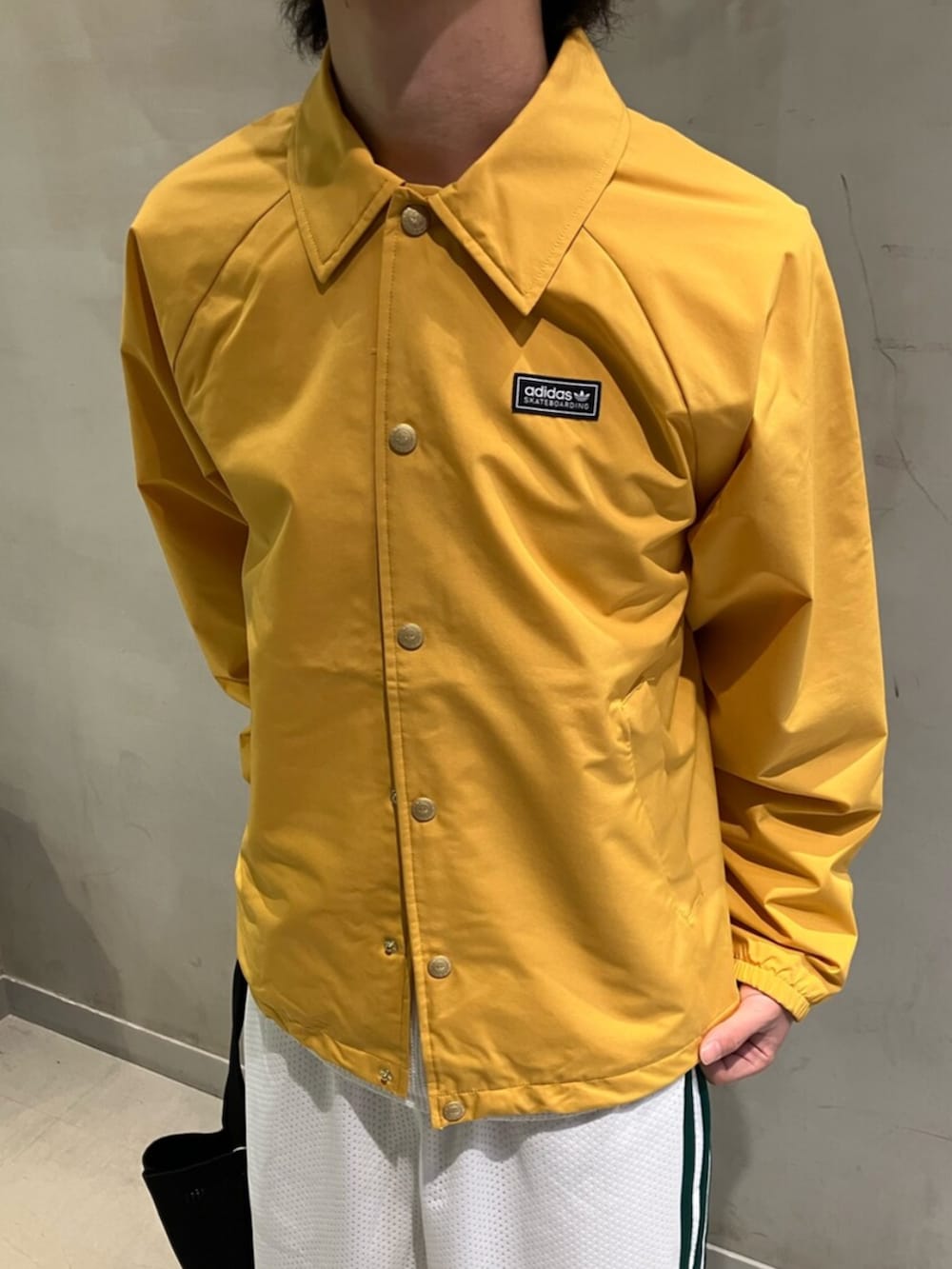 ホワイト系のシューズ、ホワイト系のその他パンツ、イエロー系のブルゾンを着用したメンズの冬コーディネートの2枚目の写真