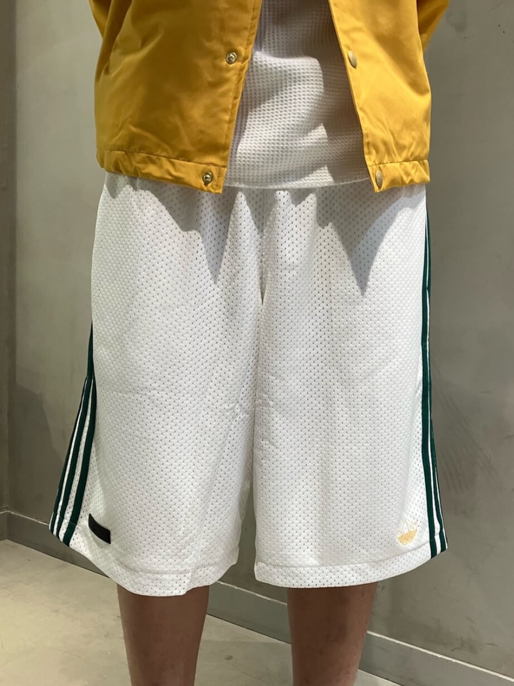 ホワイト系のシューズ、ホワイト系のその他パンツ、イエロー系のブルゾンを着用したメンズの冬コーディネートの3枚目の写真