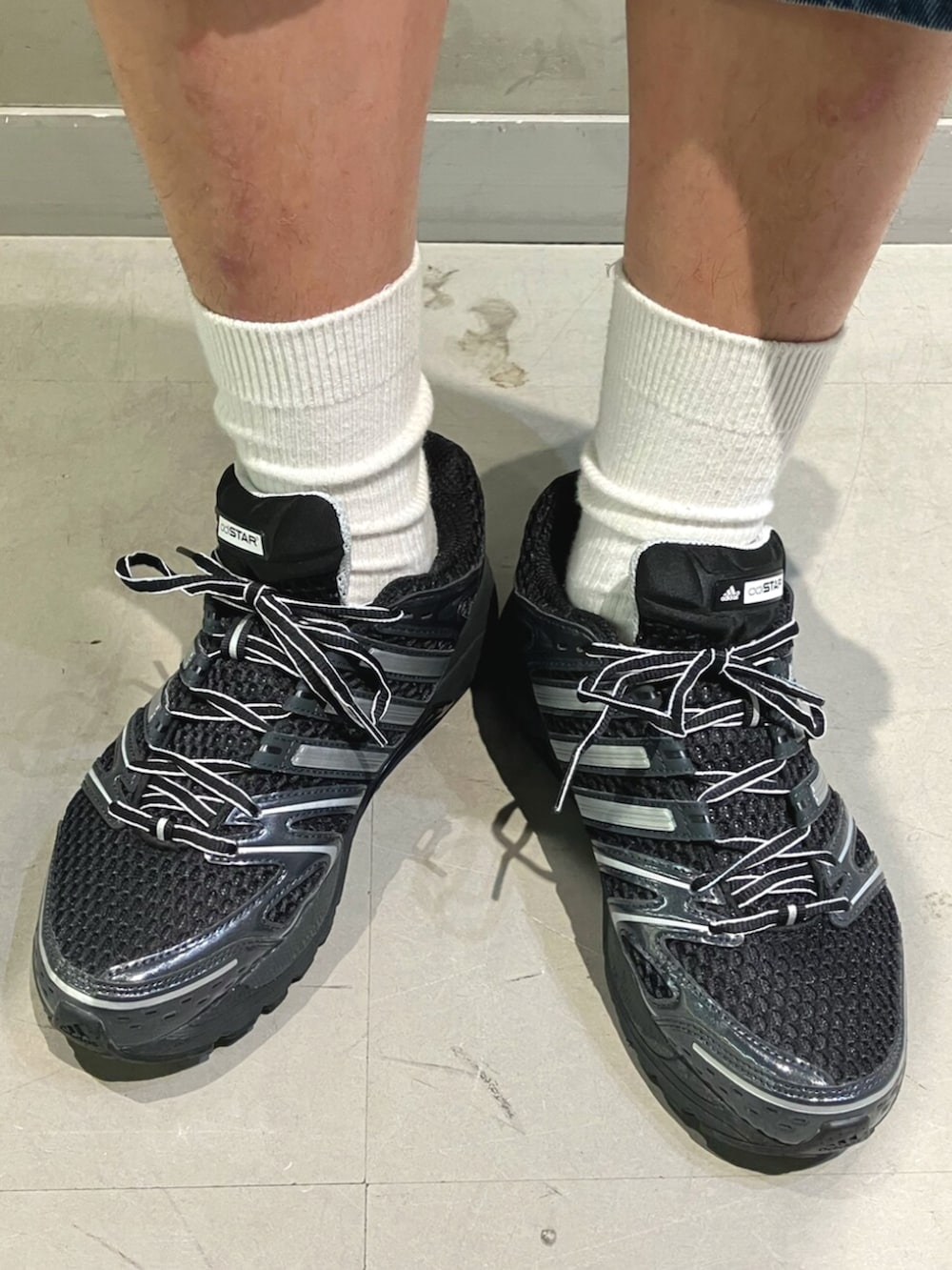 ブラック系のパーカー、ブラック系のショルダーバッグ、ブラック系のスニーカーを着用したメンズの冬コーディネートの6枚目の写真