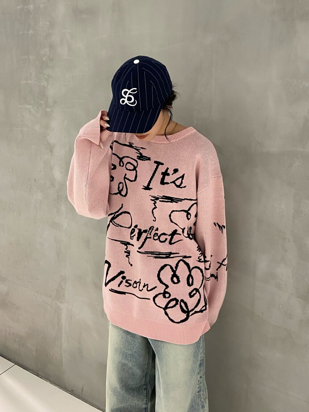 ピンク系のニット/セーター、ブルー系のデニムパンツ、ブルー系のキャップを着用したレディースの秋コーディネートの3枚目の写真