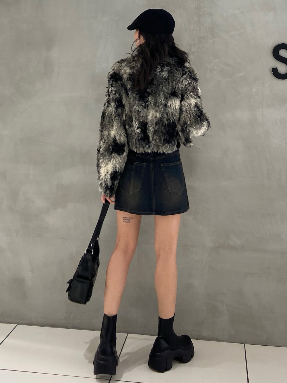 ブラック系のブルゾン、ブルー系のデニムスカート、ブラック系のショルダーバッグを着用したレディースの夏コーディネートの2枚目の写真