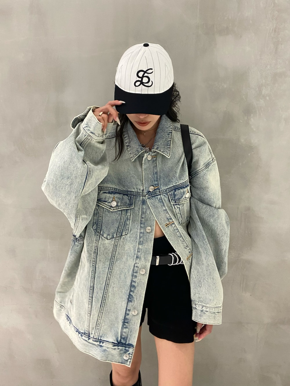 ブルー系のデニムジャケット、ブラック系のスラックス、ブラック系のブーツを着用したレディースの秋コーディネートの3枚目の写真