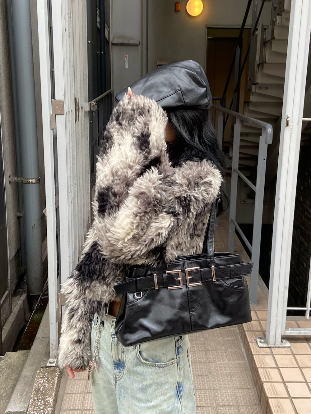 ブラック系のブルゾン、ブルー系のデニムパンツ、ブラック系のショルダーバッグを着用したレディースの秋コーディネートの3枚目の写真