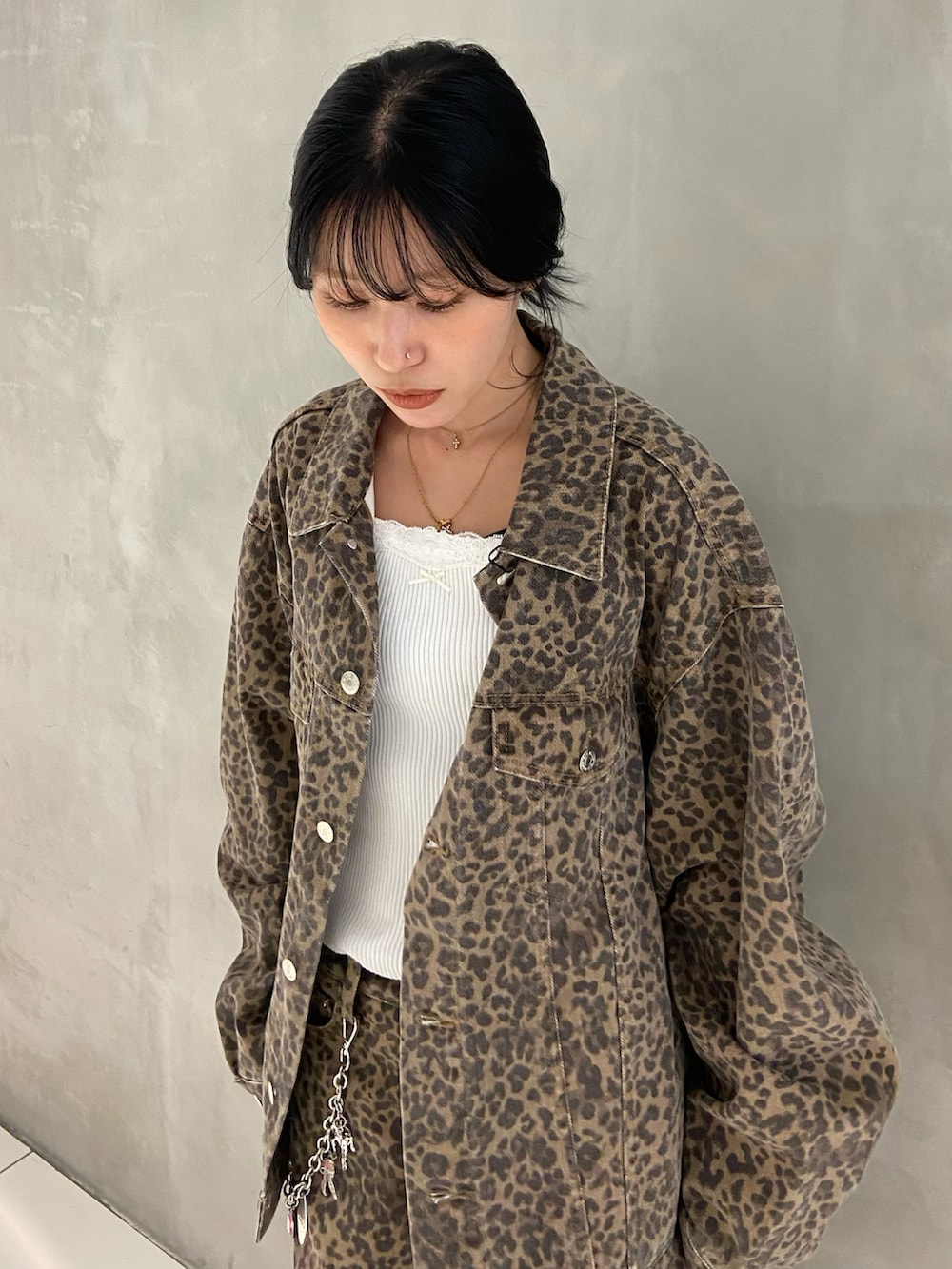 ホワイト系のタンクトップ、ブラウン系のデニムジャケット、ブラウン系のデニムパンツを着用したレディースの秋コーディネートの2枚目の写真