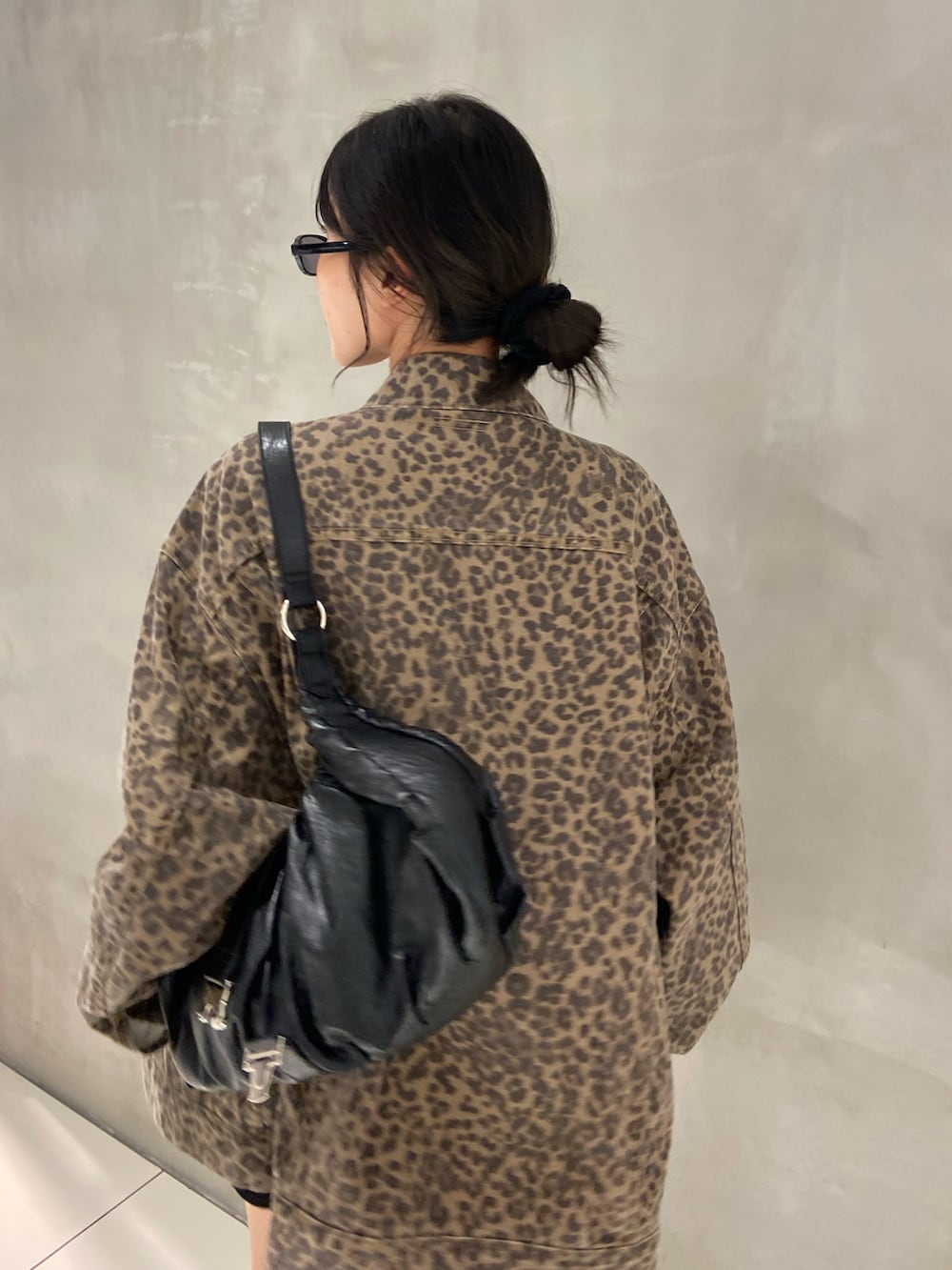 ブラウン系のデニムジャケット、ブラック系のスラックス、ブラック系のブーツを着用したレディースの秋コーディネートの3枚目の写真