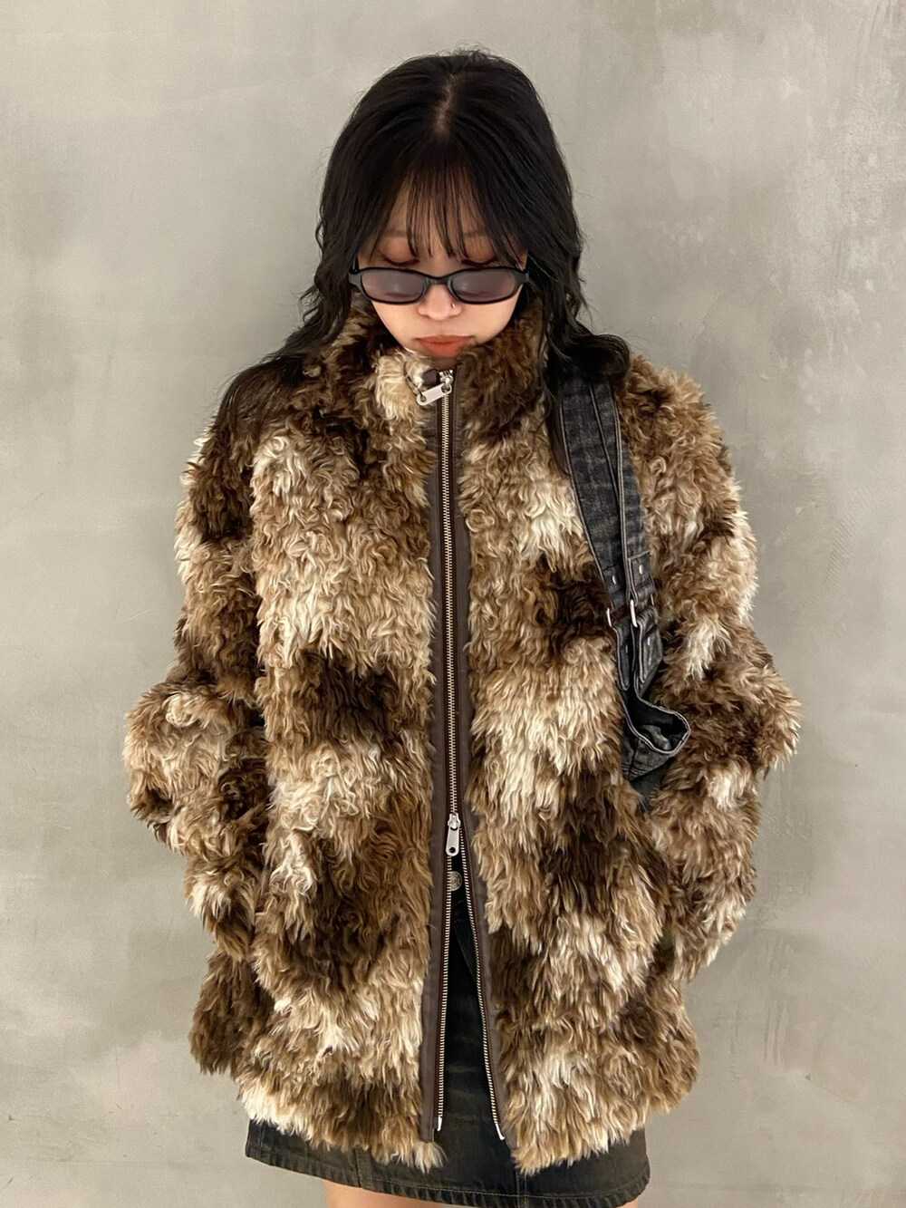 ブラウン系のブルゾン、ブラック系のトートバッグ、ブラック系のブーツを着用したレディースの夏コーディネートの2枚目の写真