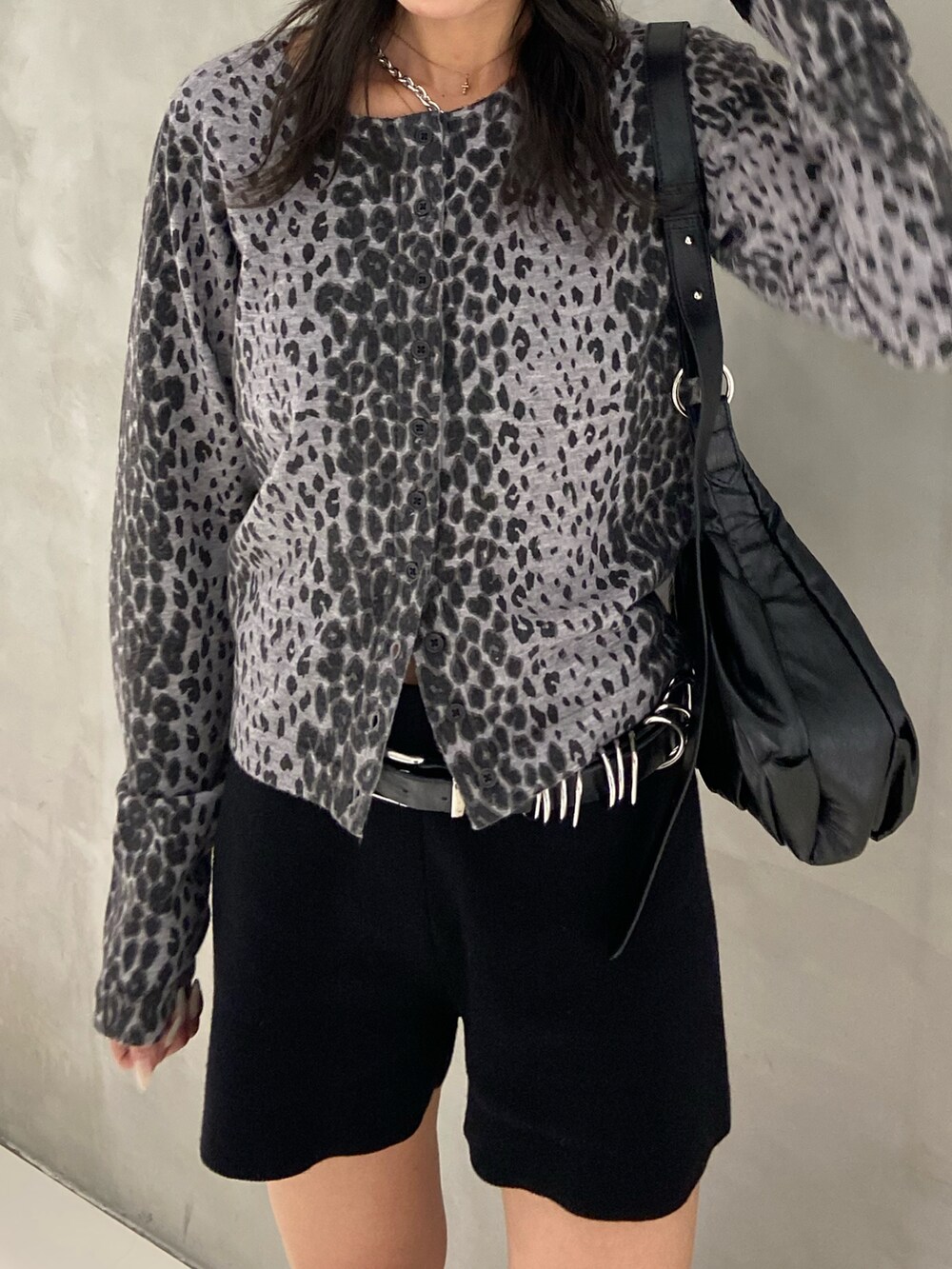 ブラック系のカーディガン/ボレロ、ブラック系のトートバッグ、ブラック系のスラックスを着用したレディースの秋コーディネートの2枚目の写真