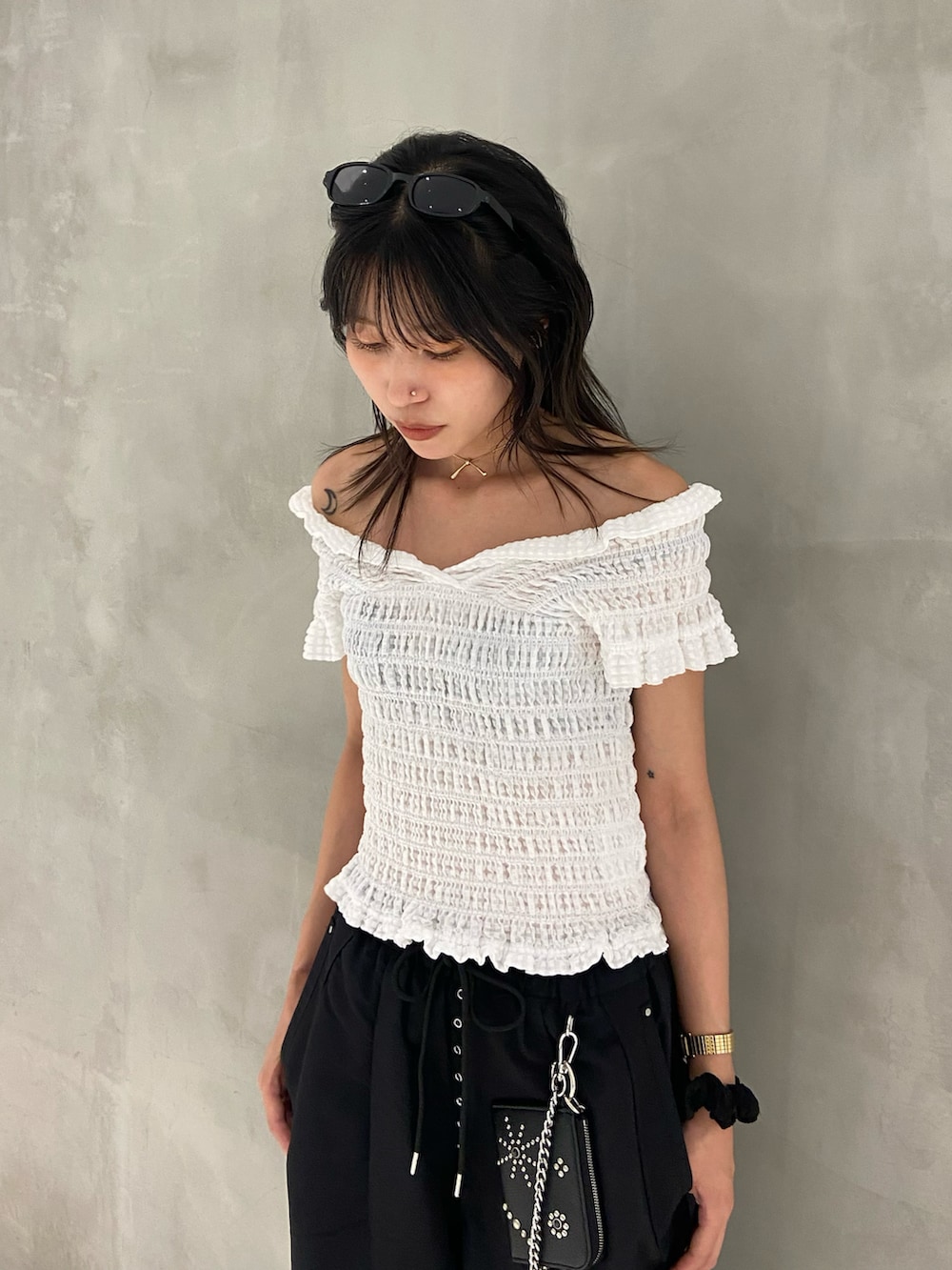 ホワイト系のTシャツ/カットソー、ブラック系のブーツ、ブラック系のスラックスを着用したレディースの夏コーディネートの2枚目の写真