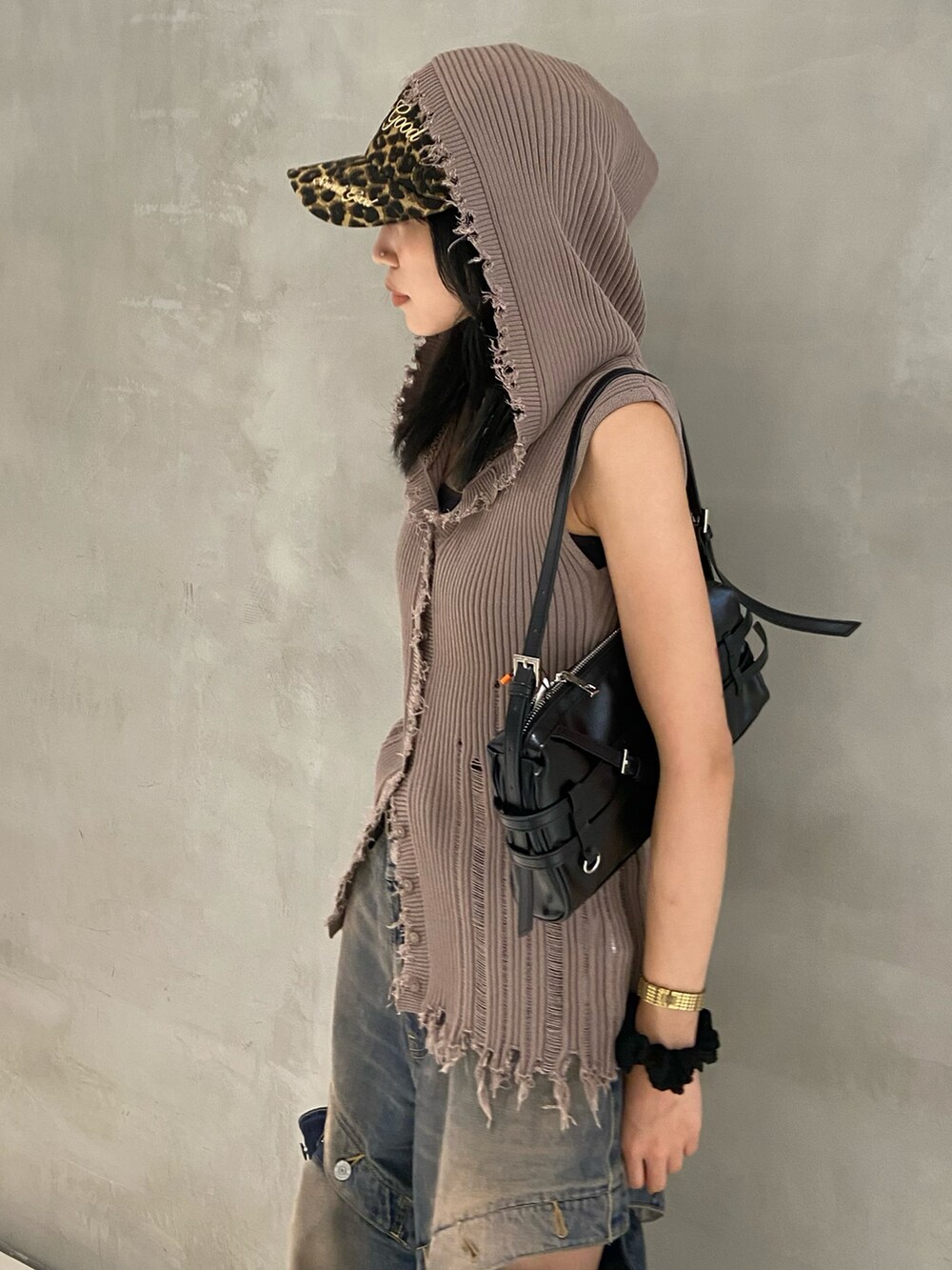 ブラック系のスニーカー、ブルー系のデニムパンツ、ベージュ系のニット/セーターを着用したレディースの夏コーディネートの2枚目の写真