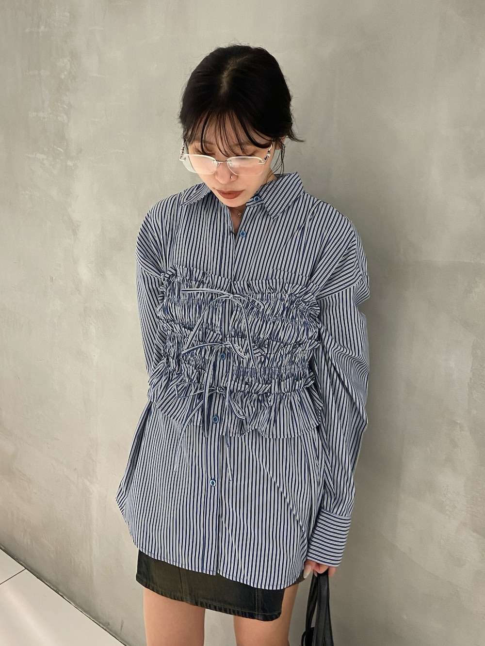 ブルー系のシャツ/ブラウス、ブルー系のデニムスカート、ブラック系のショルダーバッグを着用したレディースの秋コーディネートの3枚目の写真