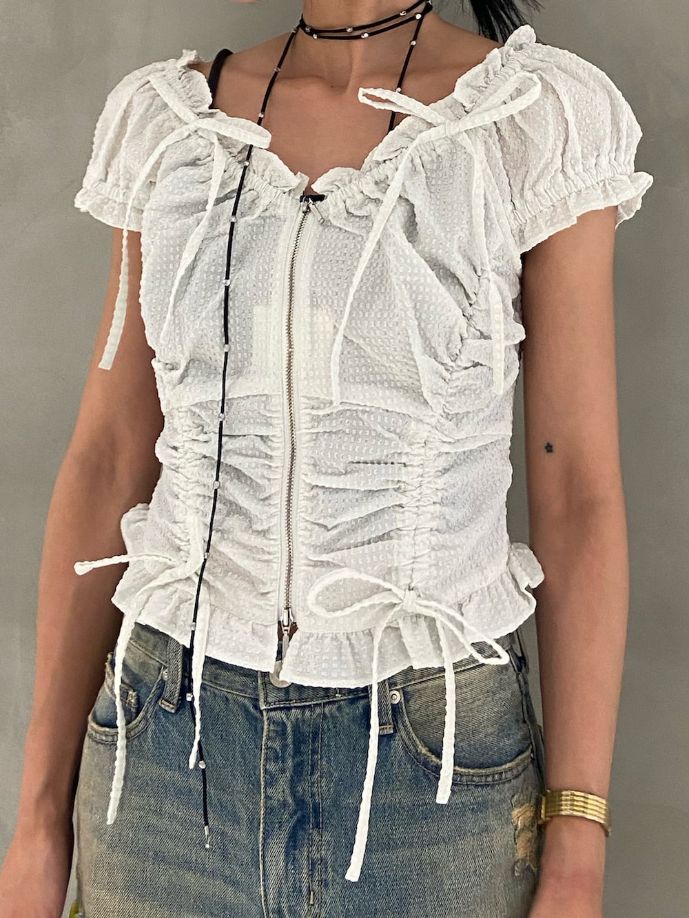 ホワイト系のシャツ/ブラウス、ブルー系のデニムパンツ、ブラウン系のハンドバッグを着用したレディースの夏コーディネートの2枚目の写真