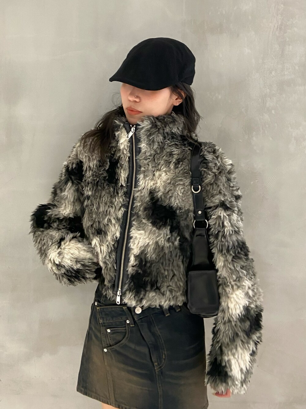 ブラック系のブルゾン、ブルー系のデニムスカート、ブラック系のショルダーバッグを着用したレディースの夏コーディネートの3枚目の写真