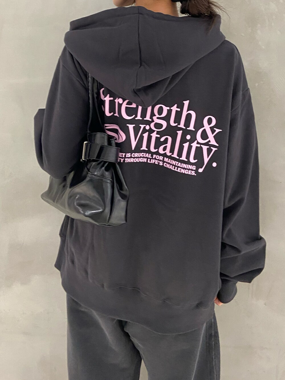 ブラック系のパーカー、ブラック系のスウェットパンツ、ブラック系のブーツを着用したレディースの秋コーディネートの4枚目の写真