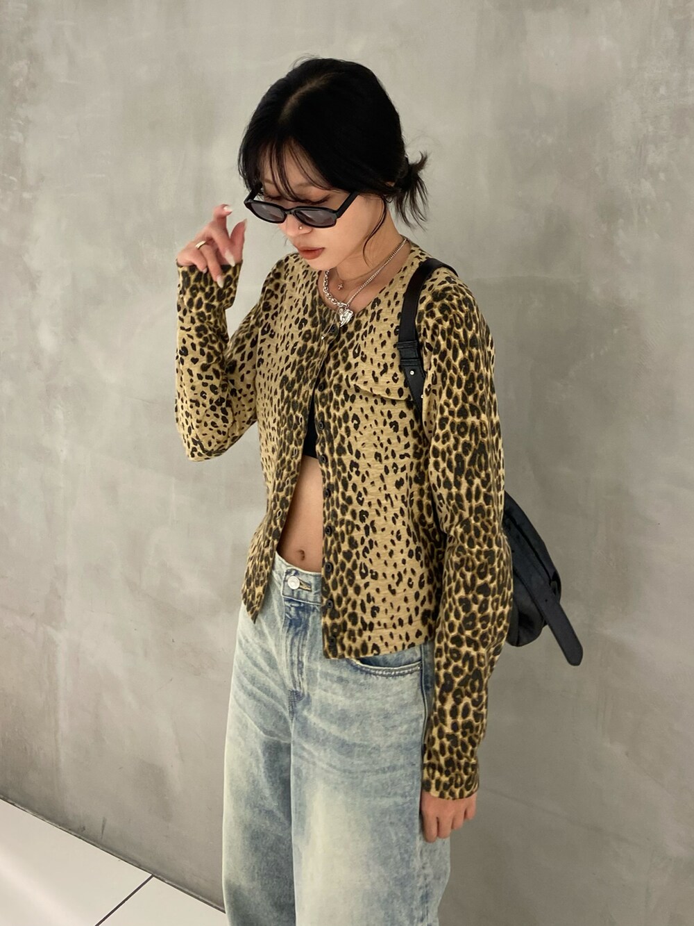 ベージュ系のカーディガン/ボレロ、ブルー系のデニムパンツ、ブラック系のトートバッグを着用したレディースの秋コーディネートの2枚目の写真