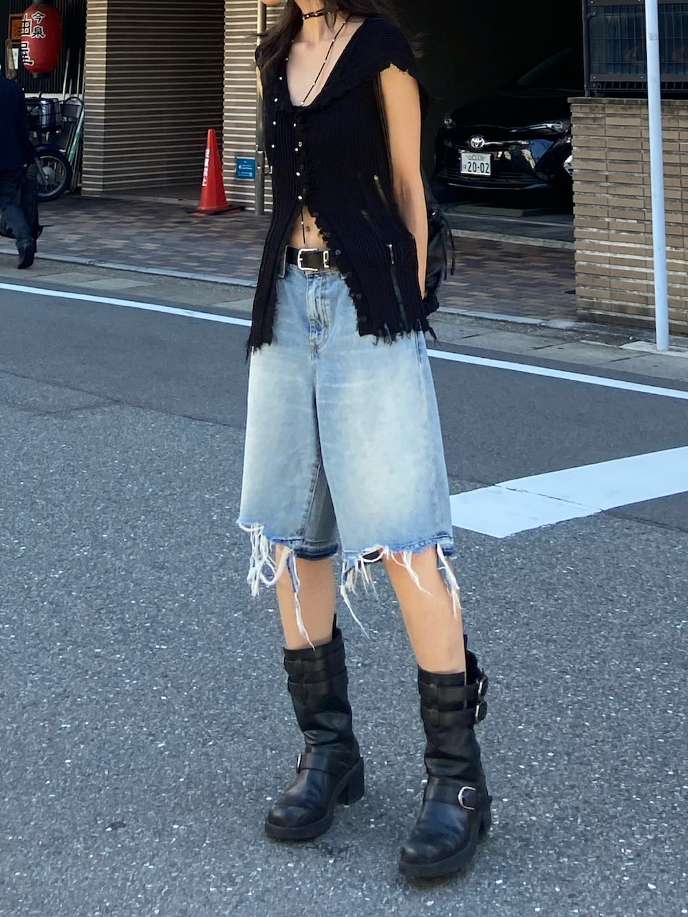 ブラック系のブーツ、ブルー系のデニムパンツ、ブラック系のニット/セーターを着用したレディースの夏コーディネートの3枚目の写真