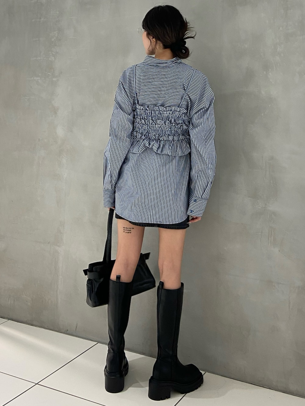 ブルー系のシャツ/ブラウス、ブルー系のデニムスカート、ブラック系のショルダーバッグを着用したレディースの秋コーディネートの2枚目の写真