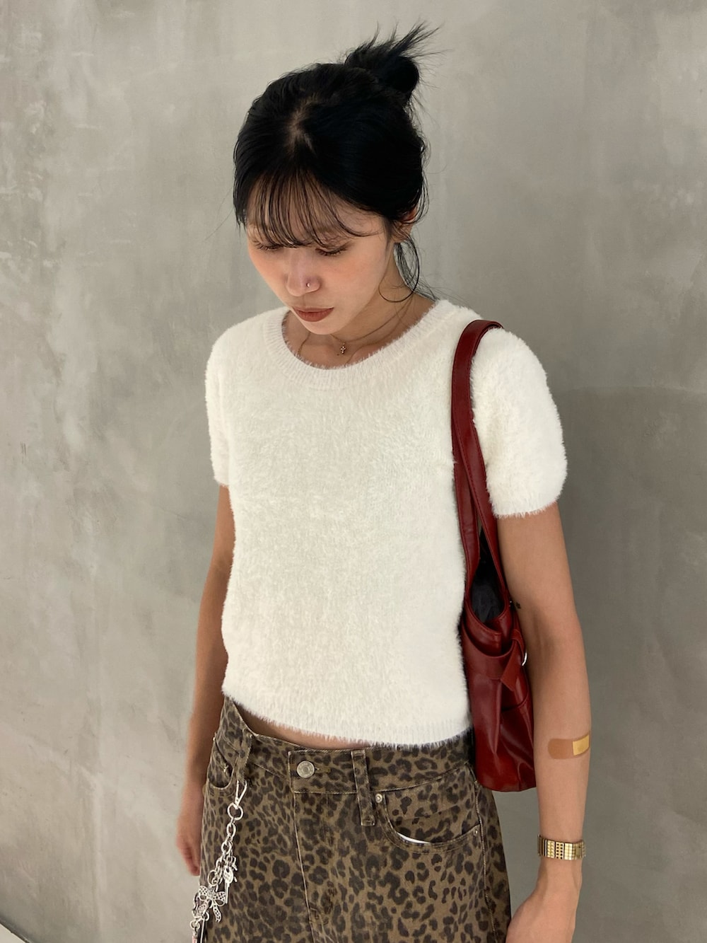 ホワイト系のニット/セーター、ブラウン系のデニムパンツ、ブラック系のブーツを着用したレディースの秋コーディネートの2枚目の写真