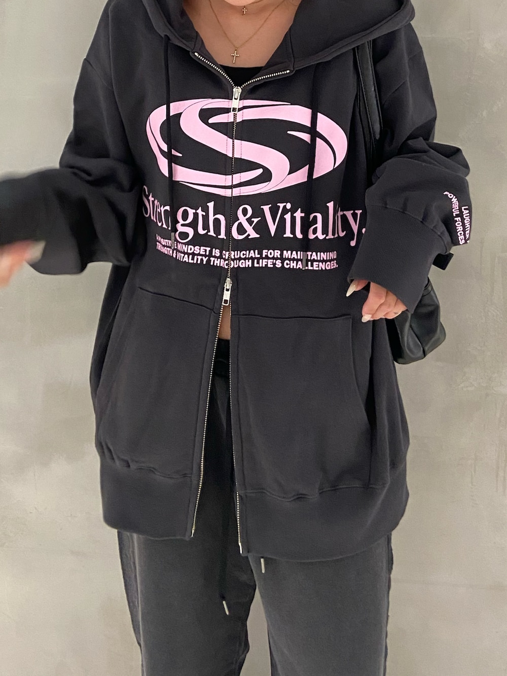 ブラック系のパーカー、ブラック系のスウェットパンツ、ブラック系のブーツを着用したレディースの秋コーディネートの3枚目の写真