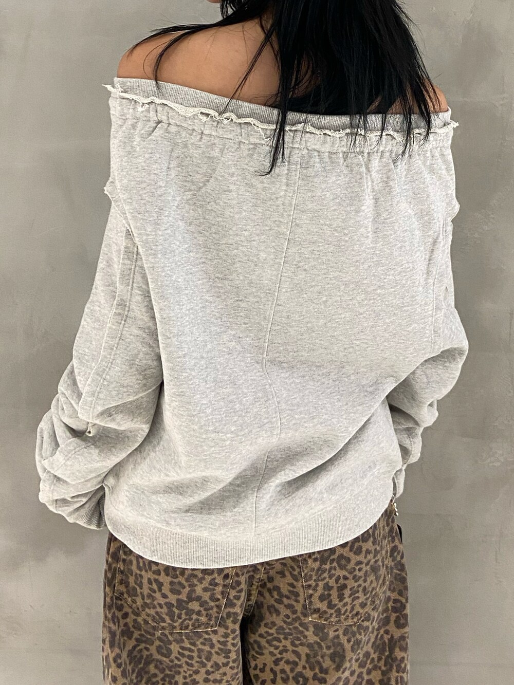 グレー系のスウェット、ブラック系のショルダーバッグ、ブラウン系のデニムパンツを着用したレディースの秋コーディネートの3枚目の写真