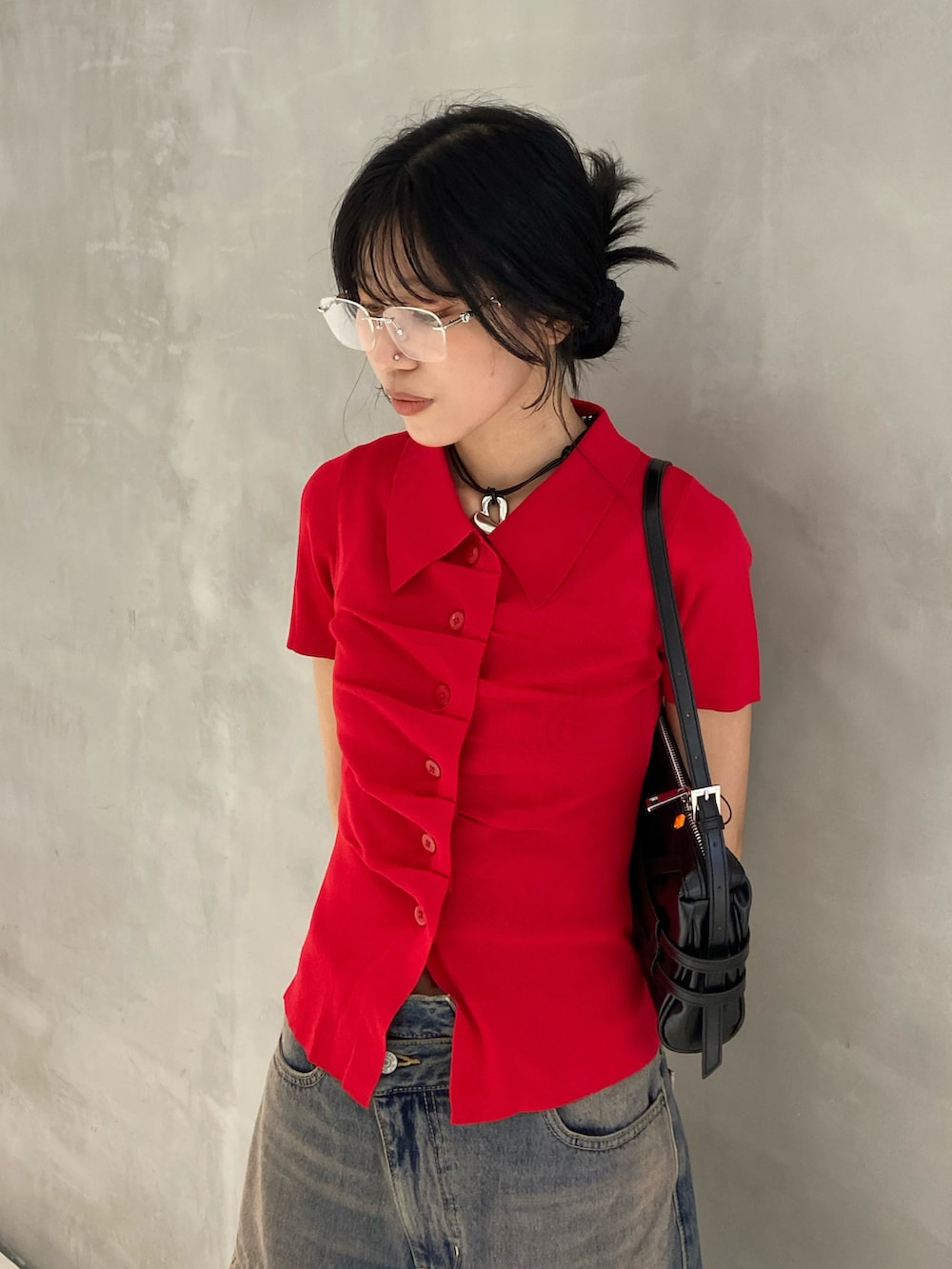 レッド系のニット/セーター、ブルー系のデニムパンツ、ブラック系のサンダルを着用したレディースの夏コーディネートの2枚目の写真
