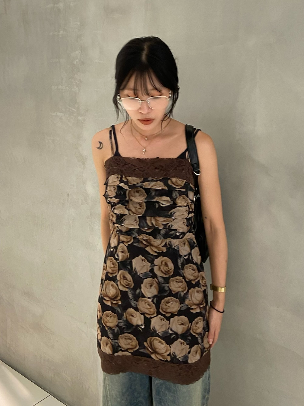 ブラウン系のワンピース、ブルー系のデニムパンツ、ブラック系のブーツを着用したレディースの夏コーディネートの3枚目の写真