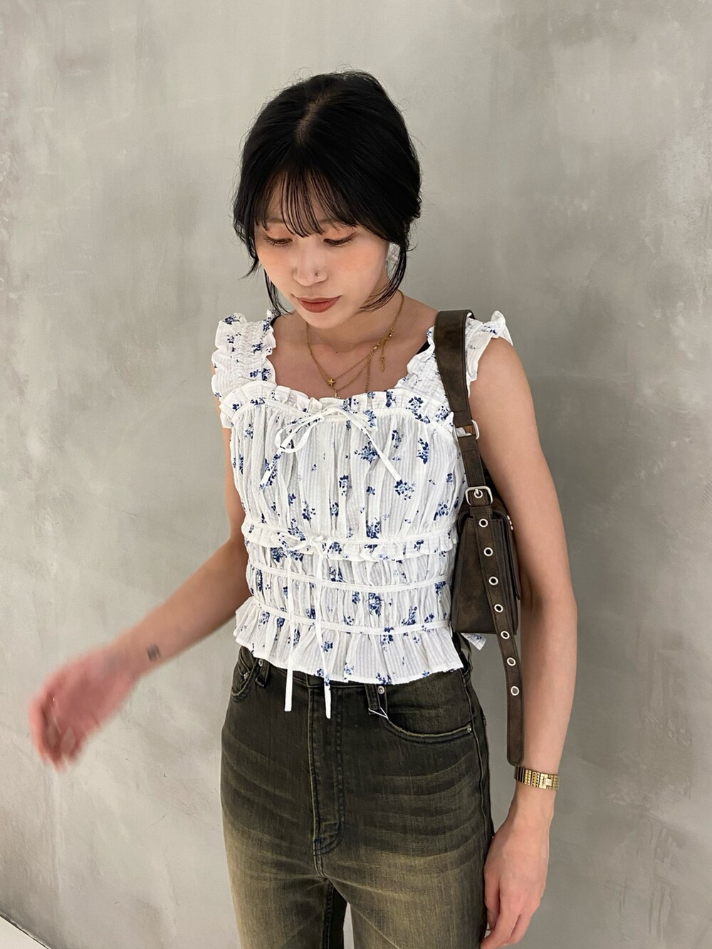 ホワイト系のシャツ/ブラウス、ブラウン系のハンドバッグ、ブラック系のデニムパンツを着用したレディースの春コーディネートの2枚目の写真
