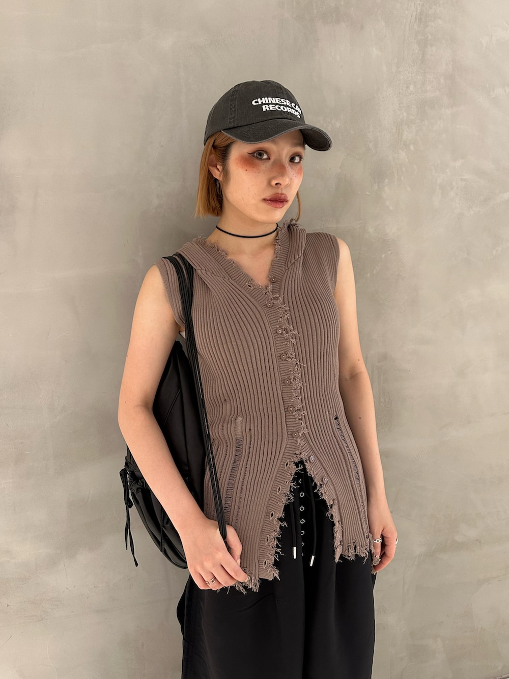 ブラック系のスラックス、ブラック系のスニーカー、ブラック系のバックパック/リュックを着用したレディースの夏コーディネートの3枚目の写真