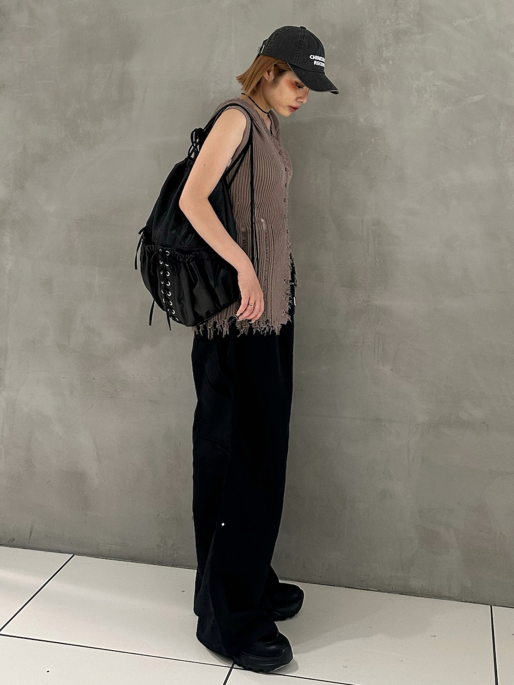 ブラック系のスラックス、ブラック系のスニーカー、ブラック系のバックパック/リュックを着用したレディースの夏コーディネートの2枚目の写真