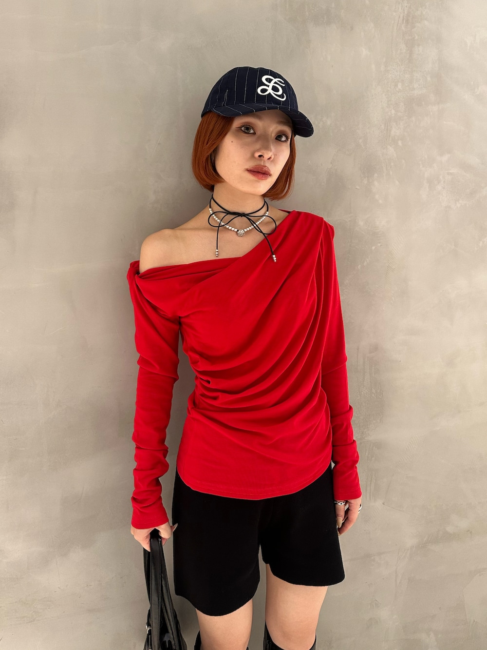 ブラック系のブーツ、ブラック系のショルダーバッグ、ブラック系のスラックスを着用したレディースの秋コーディネートの3枚目の写真