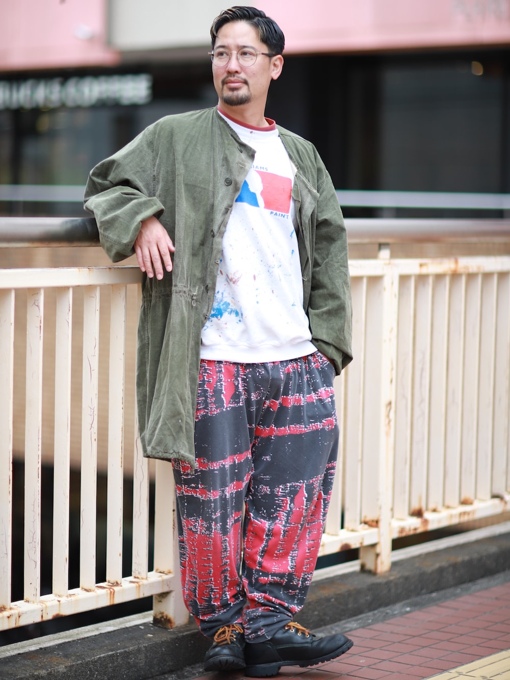 レッド系のその他パンツ、グリーン系のその他アウター、ホワイト系のスウェットを着用したメンズの春コーディネートの2枚目の写真
