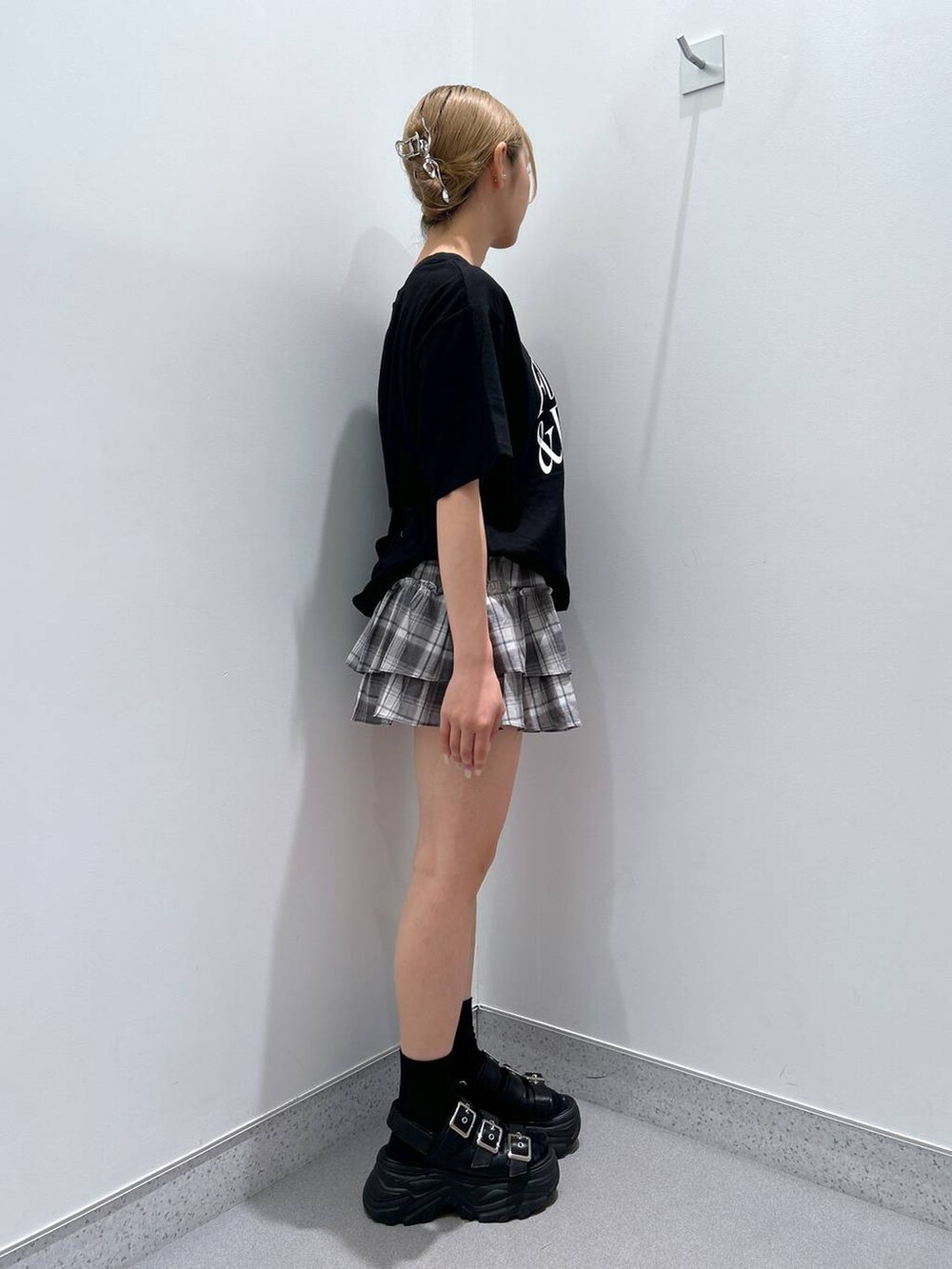 ブラック系のサンダル、ブラック系のTシャツ/カットソー、グレー系のスカートを着用したレディースの夏コーディネートの2枚目の写真