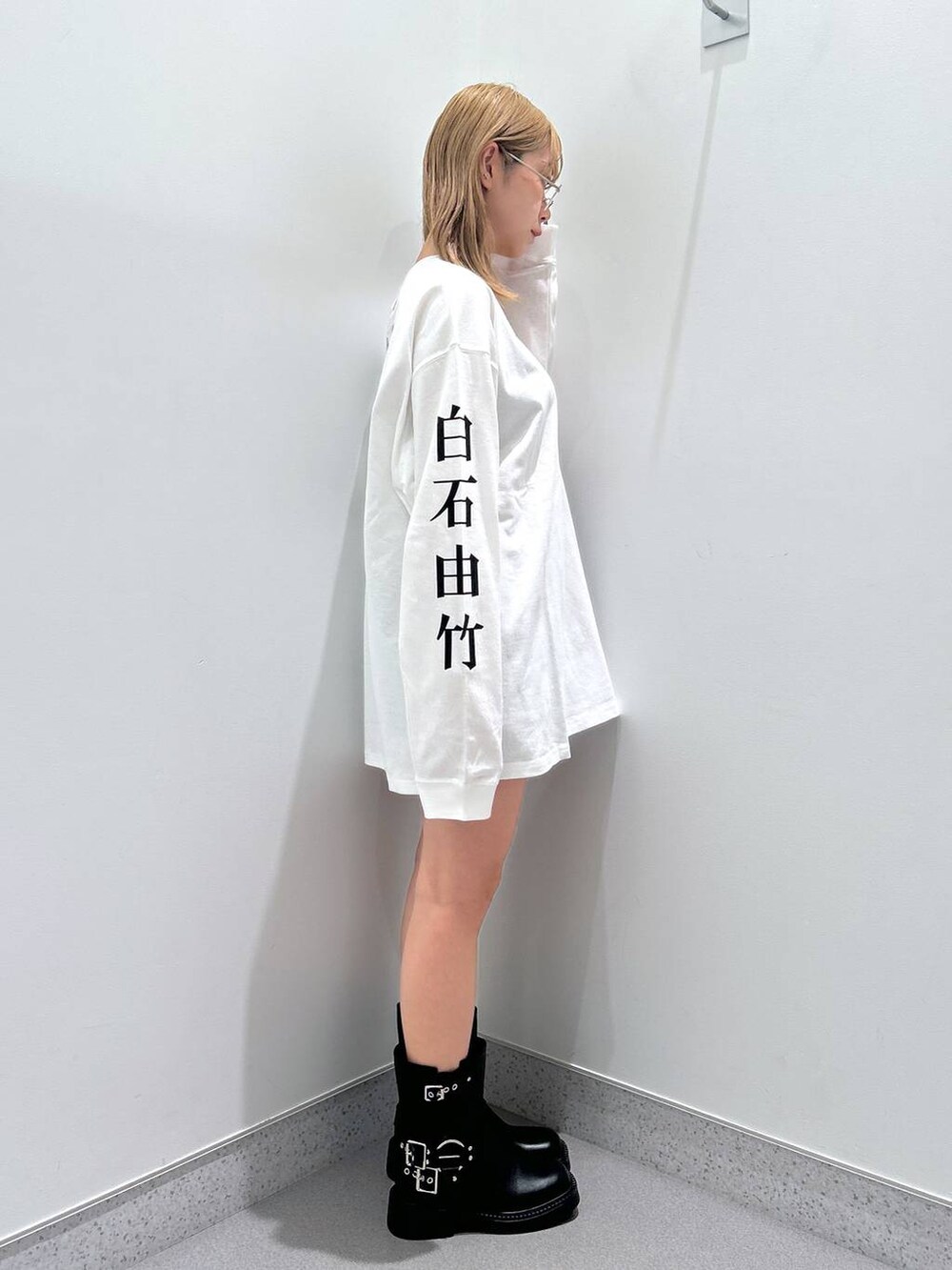 ブラック系のその他パンツ、ブラック系のブーツ、ホワイト系のTシャツ/カットソーを着用したレディースの冬コーディネートの3枚目の写真