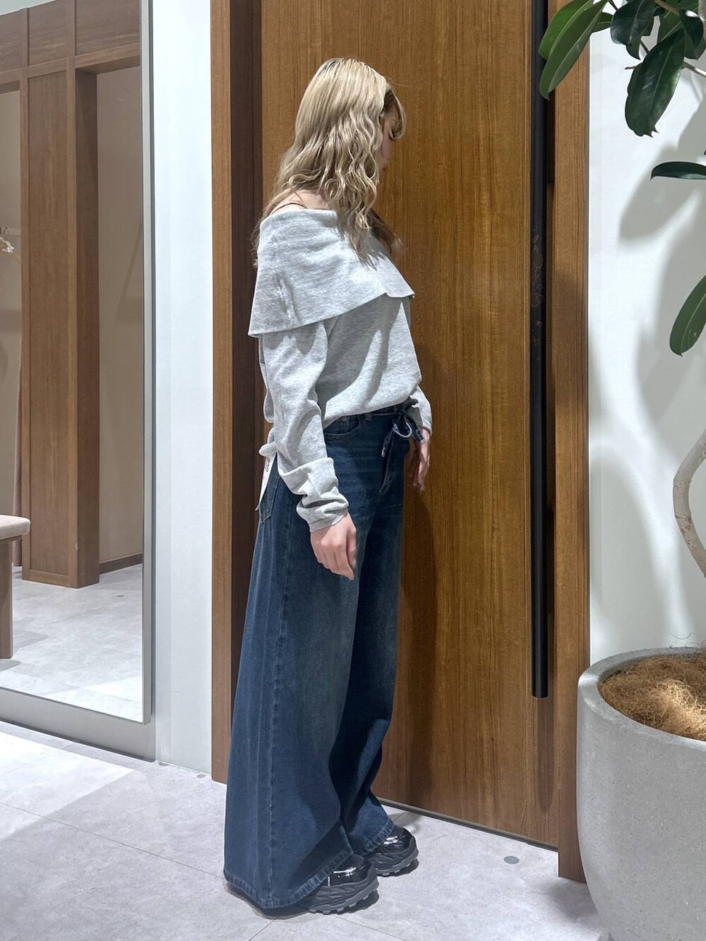 ブルー系のデニムパンツ、グレー系のニット/セーターを着用したレディースの春コーディネートの2枚目の写真