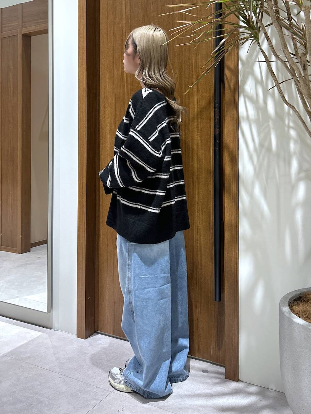 ブルー系のデニムパンツ、ブラック系のニット/セーターを着用したレディースの冬コーディネートの2枚目の写真