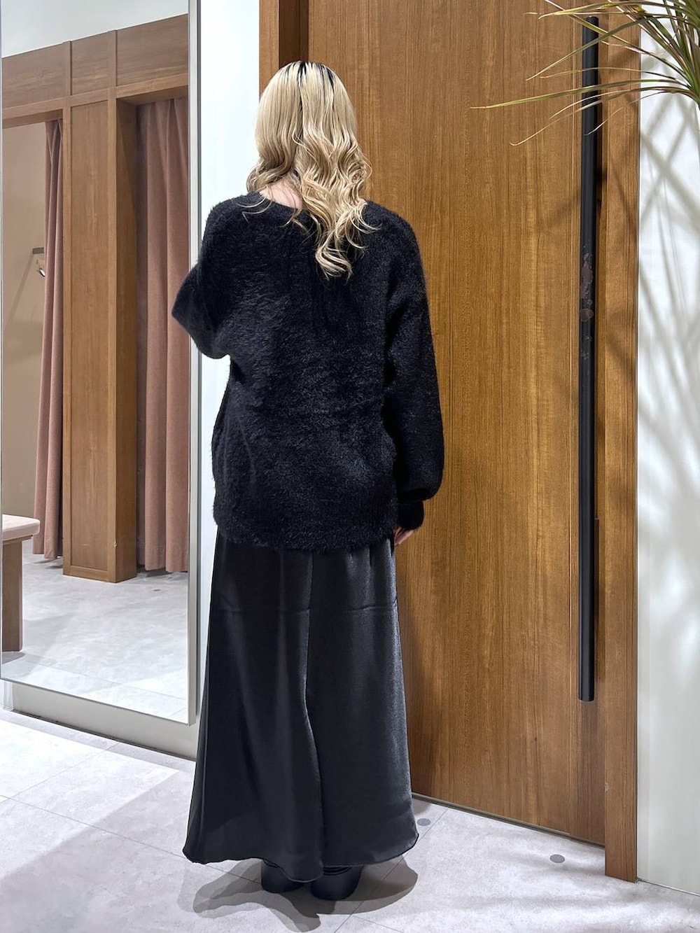 ブラック系のブーツ、ブラック系のスカート、ブラック系のカーディガン/ボレロを着用したレディースの秋コーディネートの3枚目の写真