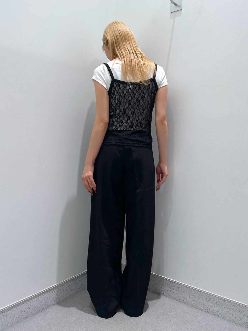 ブラック系のモカシン/デッキシューズ、ホワイト系のTシャツ/カットソー、ブラック系のスラックスを着用したレディースの夏コーディネートの3枚目の写真