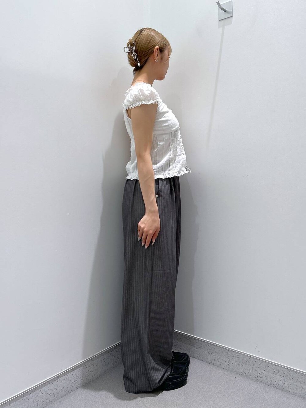 ホワイト系のシャツ/ブラウス、グレー系のスラックスを着用したレディースの夏コーディネートの2枚目の写真