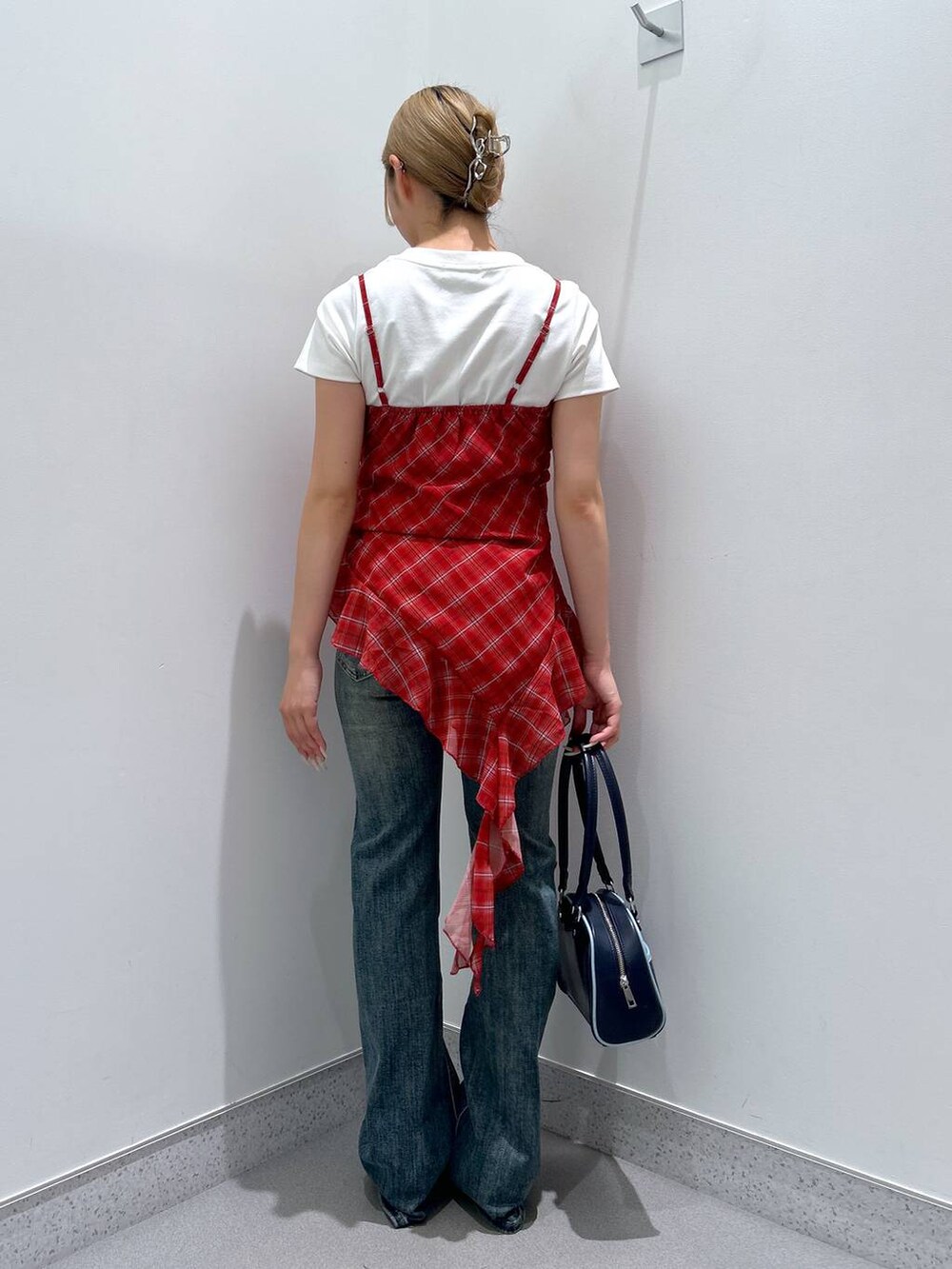 ブルー系のデニムパンツ、ブルー系のボストンバッグ、ブラック系のパンプスを着用したレディースの夏コーディネートの3枚目の写真