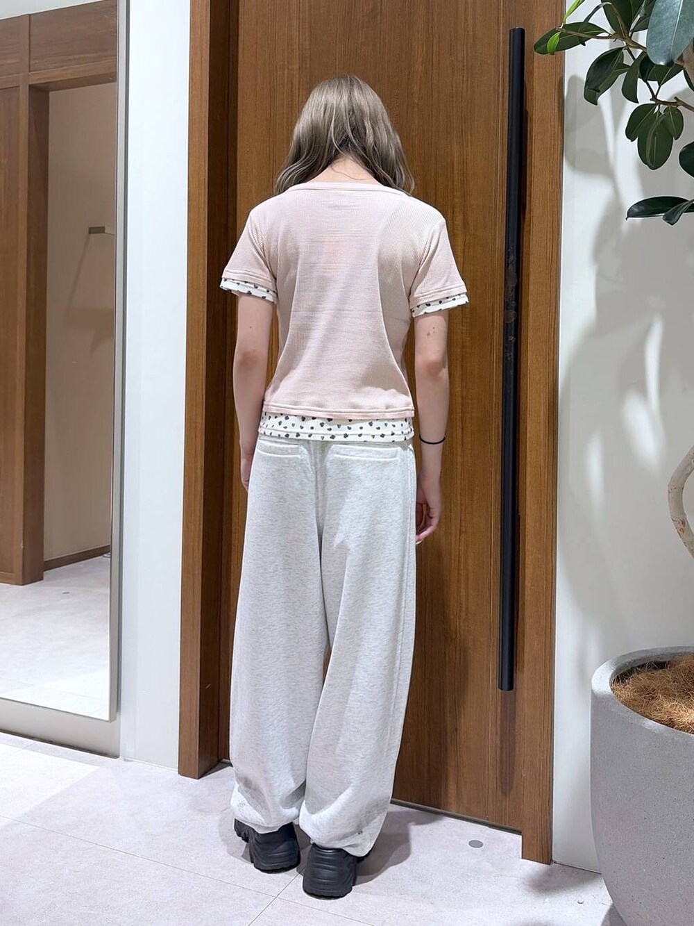 ベージュ系のスウェットパンツ、ピンク系のTシャツ/カットソーを着用したレディースの夏コーディネートの3枚目の写真