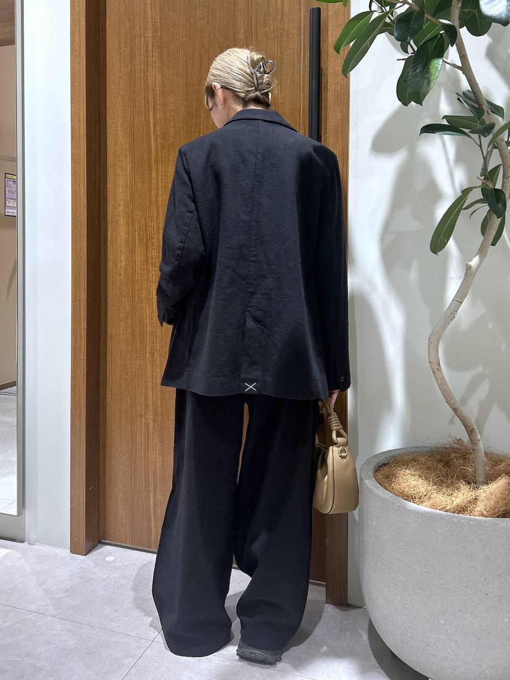 ベージュ系のハンドバッグ、ブラック系のテーラードジャケット、ブラック系のその他パンツを着用したレディースの春コーディネートの3枚目の写真