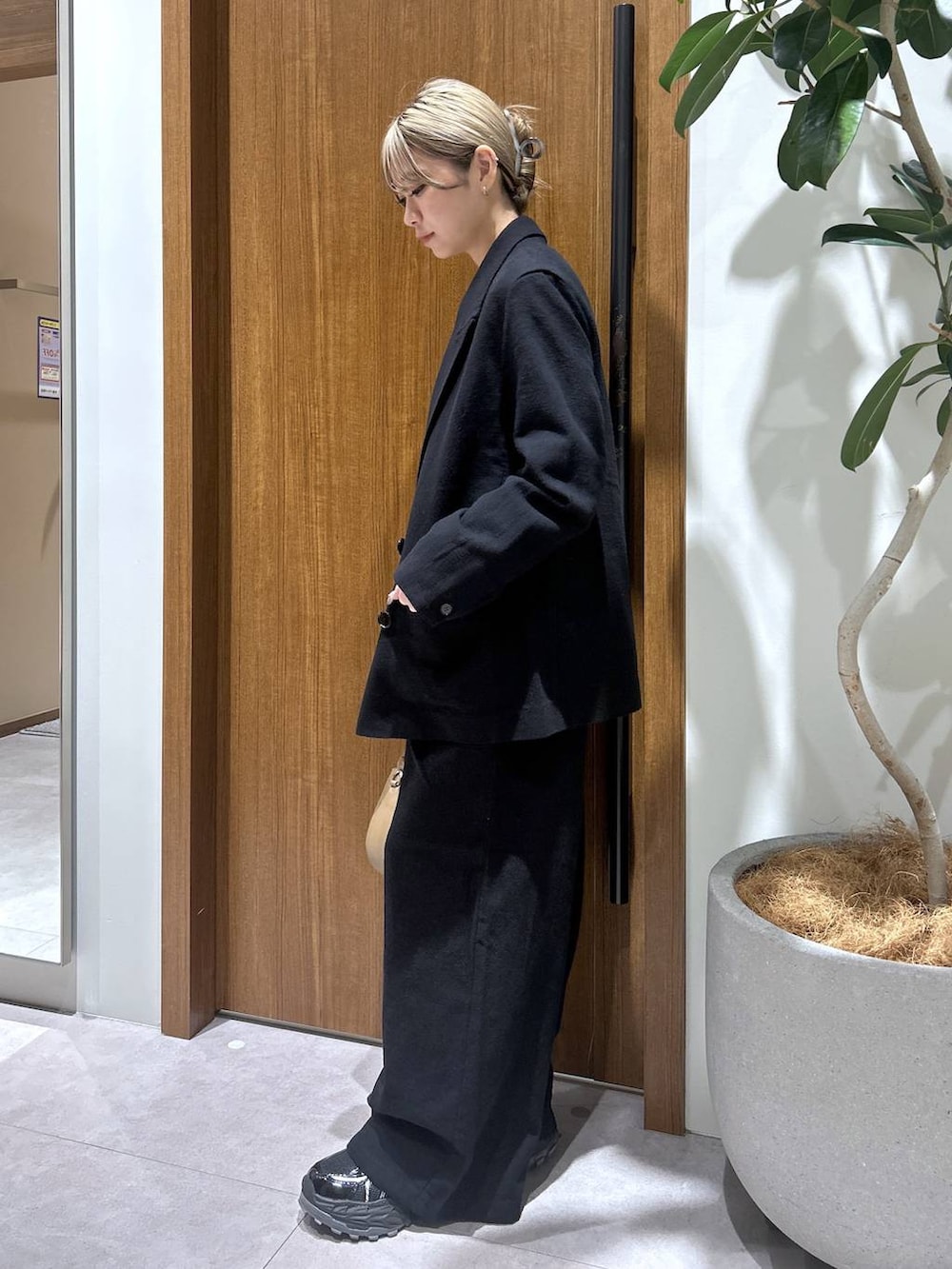 ベージュ系のハンドバッグ、ブラック系のテーラードジャケット、ブラック系のその他パンツを着用したレディースの春コーディネートの2枚目の写真