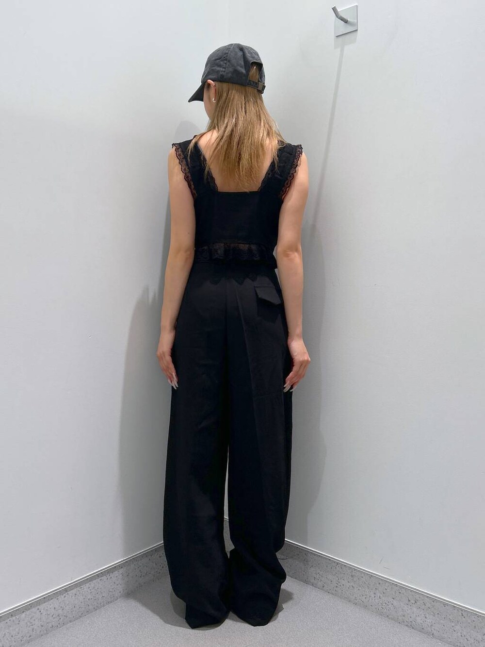 ブラウン系のモカシン/デッキシューズ、ブラック系のスラックス、ブラック系のベストを着用したレディースの夏コーディネートの4枚目の写真