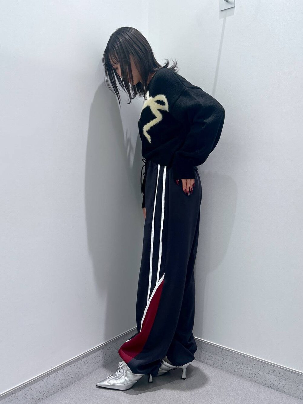 シルバー系のパンプス、ブルー系のその他パンツ、ブラック系のニット/セーターを着用したレディースの秋コーディネートの2枚目の写真