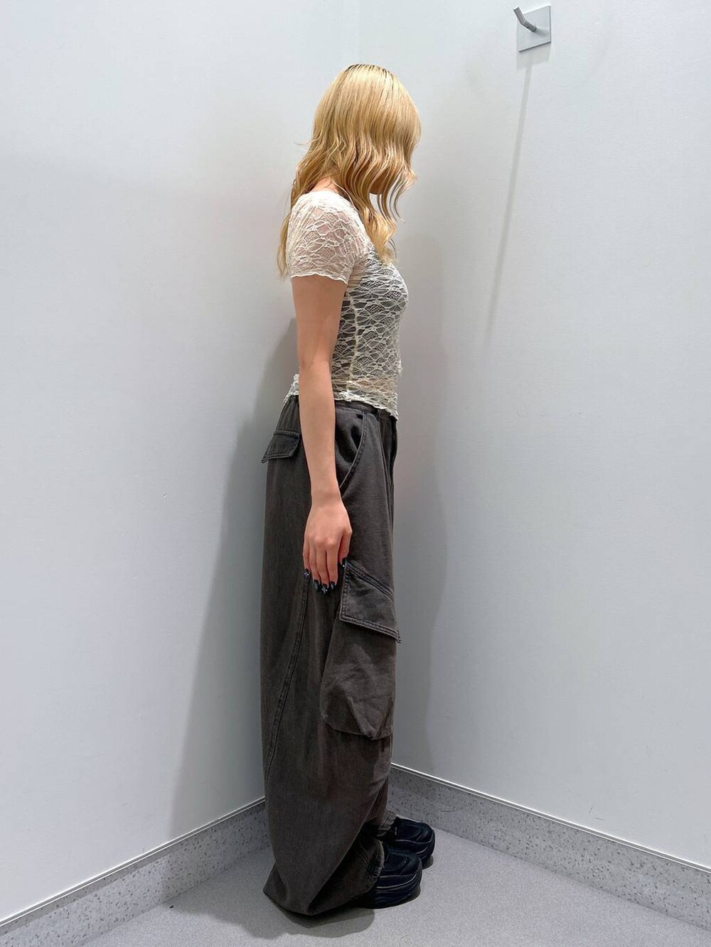 ブラック系のカーゴパンツ、ベージュ系のTシャツ/カットソーを着用したレディースの夏コーディネートの2枚目の写真