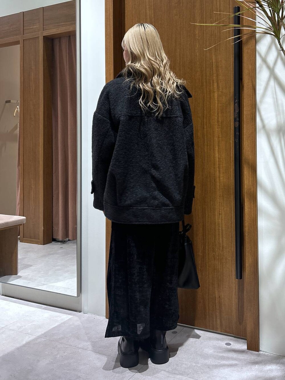 ホワイト系のTシャツ/カットソー、ブラック系のブーツ、ブラック系のスカートを着用したレディースの秋コーディネートの3枚目の写真