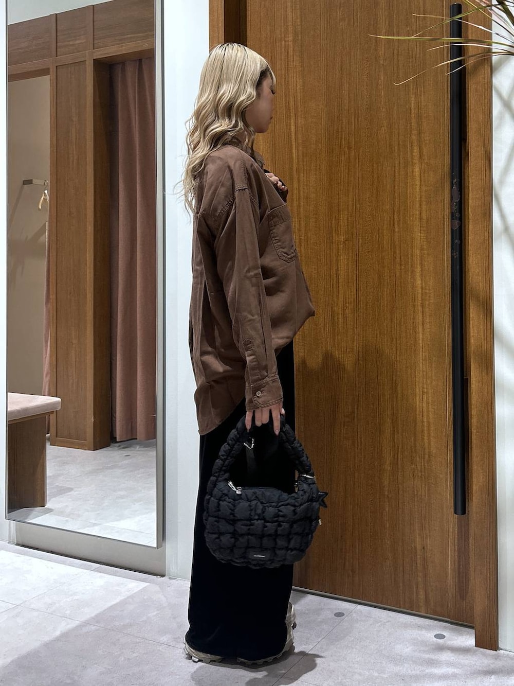 ブラック系のハンドバッグ、ブラウン系のシャツ/ブラウス、ブラック系のその他パンツを着用したレディースの秋コーディネートの2枚目の写真