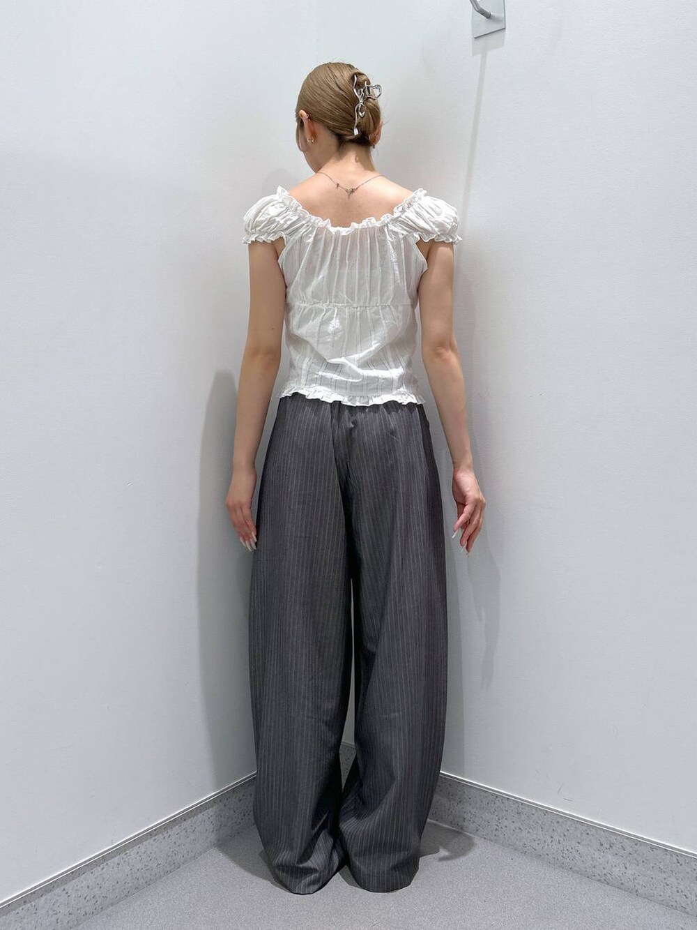 ホワイト系のシャツ/ブラウス、グレー系のスラックスを着用したレディースの夏コーディネートの3枚目の写真