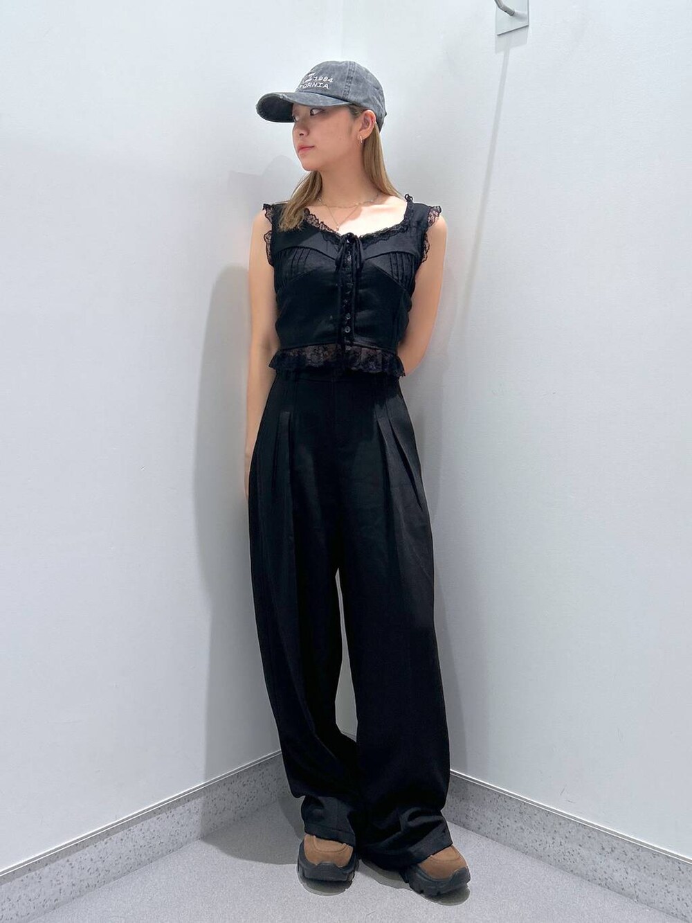 ブラウン系のモカシン/デッキシューズ、ブラック系のスラックス、ブラック系のベストを着用したレディースの夏コーディネートの2枚目の写真